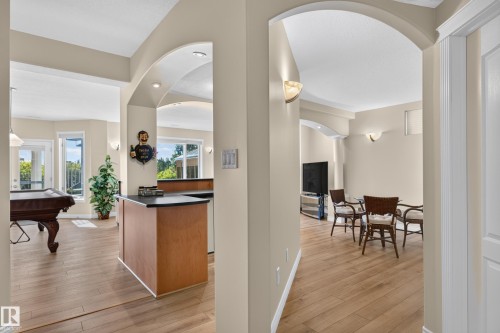 Arched room entries, wood-finish flooring, recessed lighting, wall sconces, and built-in counter - 13527 158 Avenue Nw, Edmonton, AB - Indoor Photo Showing Other Room