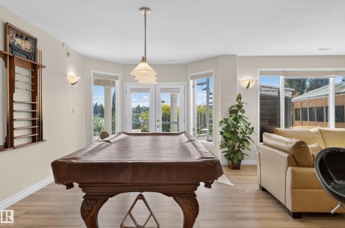 Recessed lighting, wood-finish flooring, and multiple glass doors providing outdoor access - 13527 158 Avenue Nw, Edmonton, AB - Indoor Photo Showing Other Room