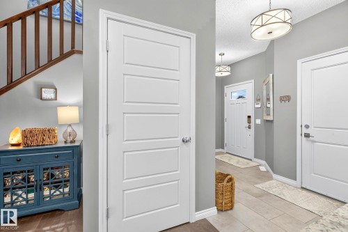 Hardwood-finish flooring, staircase with wood railing, recessed panel doors, tile flooring, and integrated lighting fixtures - 16512 140 Street Nw, Edmonton, AB - Indoor Photo Showing Other Room