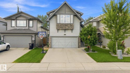 Contemporary exterior with mixed siding and stone accents, dual garage doors, concrete driveway, and landscaped front yard - 16512 140 Street Nw, Edmonton, AB - Outdoor With Facade