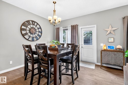 Wood-finish flooring, white walls, and a white door with a window - 16512 140 Street Nw, Edmonton, AB - Indoor Photo Showing Dining Room