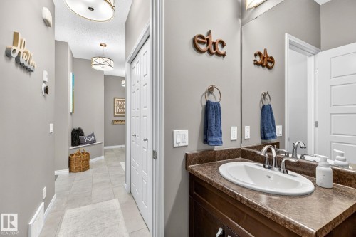Hallway featuring a built-in bench, overhead lighting, and tiled flooring - 16512 140 Street Nw, Edmonton, AB - Indoor Photo Showing Bathroom