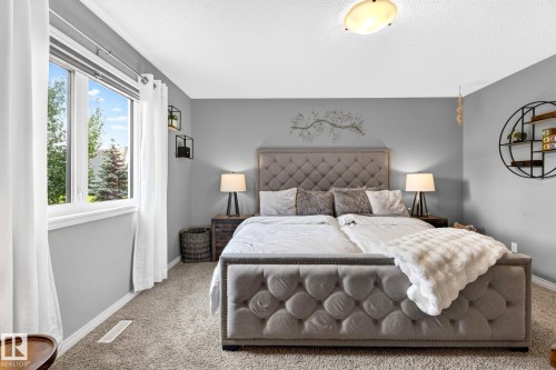 Neutral wall paint, textured carpeting, and a flush-mount ceiling light fixture - 16512 140 Street Nw, Edmonton, AB - Indoor Photo Showing Bedroom