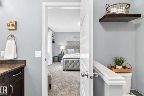 Bedroom with gray upholstered headboard and footboard, carpet flooring, and a white interior door - 16512 140 Street Nw, Edmonton, AB - Indoor