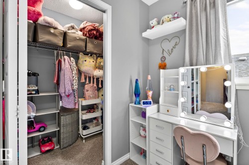Built-in closet shelving and hanging storage, light gray wall paint, and a built-in window with white trim - 16512 140 Street Nw, Edmonton, AB - Indoor