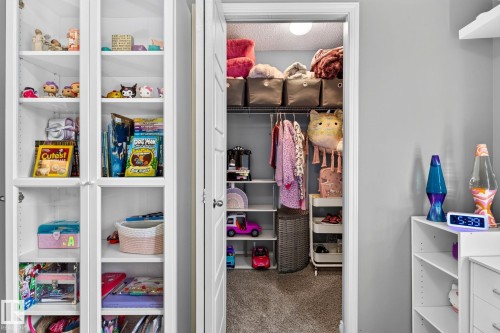Built-in white shelving, recessed lighting, and a closet with integrated shelving and a hanging rod - 16512 140 Street Nw, Edmonton, AB - Indoor