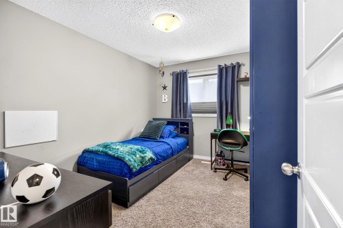 Plush carpeting, neutral wall color, window with privacy blinds, and a built-in ceiling light fixture - 16512 140 Street Nw, Edmonton, AB - Indoor Photo Showing Bedroom
