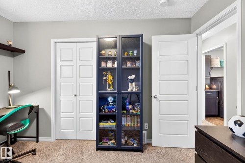 Neutral wall color, wall-mounted shelving, wood-finish flooring, white panel bi-fold closet doors, and white panel interior door - 16512 140 Street Nw, Edmonton, AB - Indoor