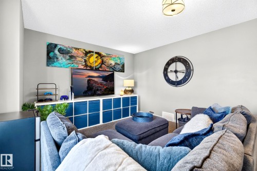 White wall paint, built-in shelving unit, overhead flush mount lighting, textured ceiling, wall-mounted clock - 16512 140 Street Nw, Edmonton, AB - Indoor