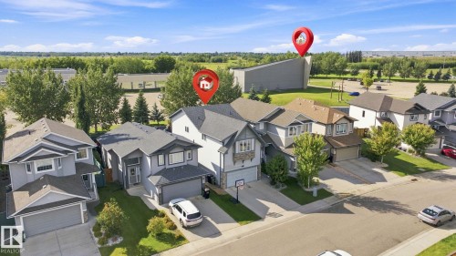 Residential street featuring detached properties, each with an attached garage and a paved driveway - 16512 140 Street Nw, Edmonton, AB - Outdoor With Deck Patio Veranda