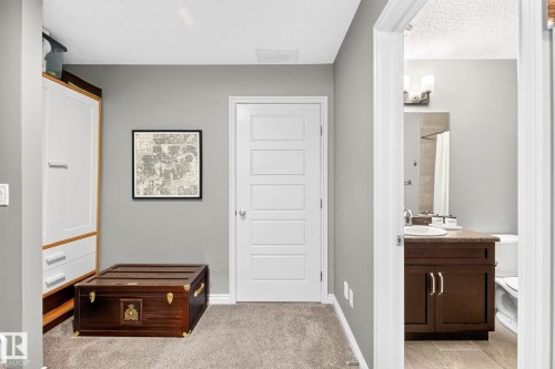 Hallway featuring plush carpeting, a modern five-panel door, and smooth wall finishes - 16512 140 Street Nw, Edmonton, AB - Indoor Photo Showing Other Room