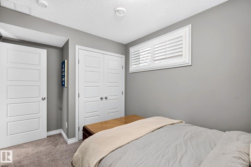 White paneled doors, carpeted flooring, and a white window with louvered shutters - 16512 140 Street Nw, Edmonton, AB - Indoor Photo Showing Bedroom