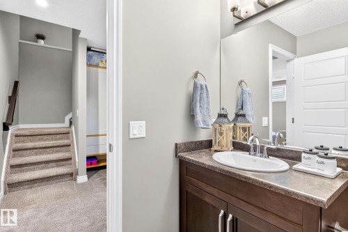 Bathroom vanity with a dark wood-finish cabinet, oval undermount sink, and polished chrome faucet - 16512 140 Street Nw, Edmonton, AB - Indoor Photo Showing Bathroom