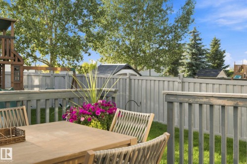 Expansive fenced yard with a manicured lawn, established trees, and a private wooden deck - 16512 140 Street Nw, Edmonton, AB - Outdoor With Deck Patio Veranda