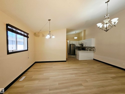 Wood-finish flooring, recessed window, contemporary pendant lighting, and an integrated kitchen with stainless steel appliances - 11625 88 Street Nw, Edmonton, AB 