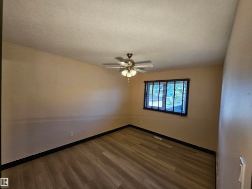 Wood-finish flooring, ceiling fan with integrated lighting, and a window with horizontal blinds - 11625 88 Street Nw, Edmonton, AB 