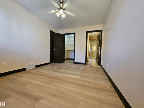 Wood-finish flooring, ceiling fan, dark wood trim, and light wall paint - 11625 88 Street Nw, Edmonton, AB 