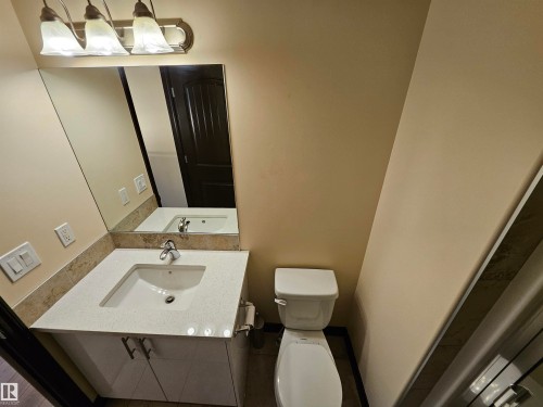 Vanity with a rectangular undermount sink, solid surface countertop, and matching backsplash - 11625 88 Street Nw, Edmonton, AB 