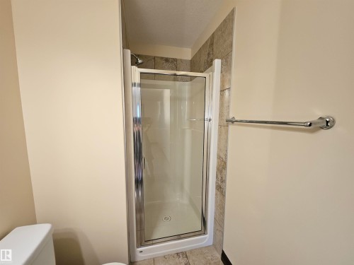 Compact shower enclosure with a clear glass door, chrome hardware, and tiled surround - 11625 88 Street Nw, Edmonton, AB 