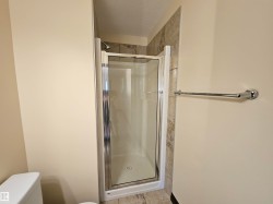 Compact shower enclosure with a clear glass door, chrome hardware, and tiled surround - 