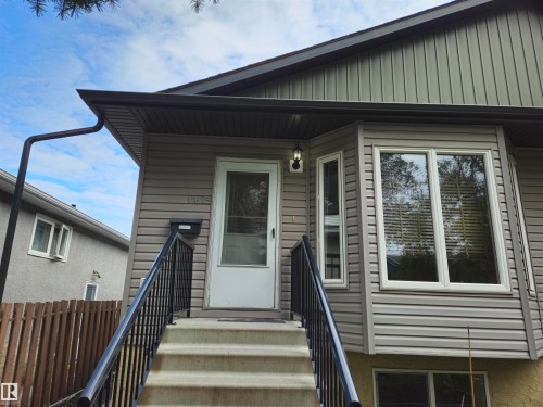 Bay window with white trim, gray siding, and a white entrance door - 11625 88 Street Nw, Edmonton, AB 