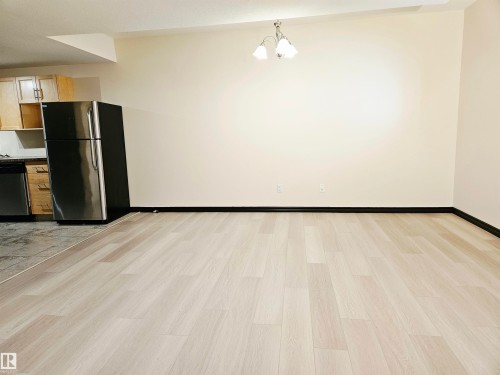 Light wood-finish flooring with contrasting dark trim - 11625 88 Street Nw, Edmonton, AB 