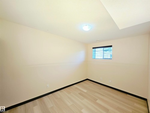 Wood-finish flooring, neutral wall tones, recessed lighting, ceiling-mounted light fixture, and a window with blinds - 11625 88 Street Nw, Edmonton, AB 
