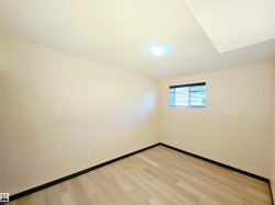 Wood-finish flooring, neutral wall tones, recessed lighting, ceiling-mounted light fixture, and a window with blinds - 