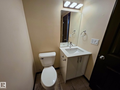 Modern vanity with a rectangular integrated sink, chrome faucet, and mirrored medicine cabinet - 11625 88 Street Nw, Edmonton, AB 