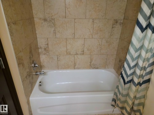 Tile surround with a white bathtub and chrome fixtures - 11625 88 Street Nw, Edmonton, AB 