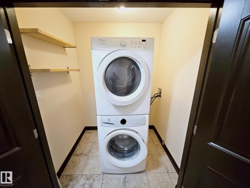 Stacked laundry appliances, integrated shelving, and tile flooring - 11625 88 Street Nw, Edmonton, AB 