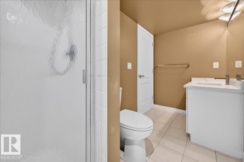 Bathroom featuring a single vanity with an integrated sink, polished chrome faucet, and white cabinetry - #1102 10909 103 Av Nw, Edmonton, AB - Indoor Photo Showing Bathroom