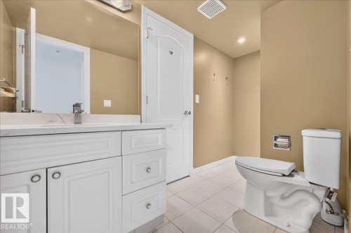 White vanity with panel detailing, integrated sink, and chrome faucet - #1102 10909 103 Av Nw, Edmonton, AB - Indoor Photo Showing Bathroom
