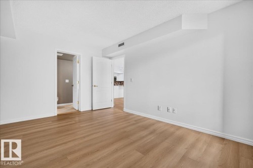 Wood-finish flooring throughout, white walls, and white trim - #1102 10909 103 Av Nw, Edmonton, AB - Indoor Photo Showing Other Room