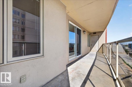 Exterior balcony featuring a concrete floor, glass and metal railing, and a sliding glass door - #1102 10909 103 Av Nw, Edmonton, AB - Outdoor With Balcony With Exterior
