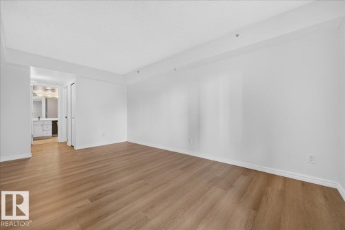 Expansive room featuring wood-finish flooring and recessed lighting - #1102 10909 103 Av Nw, Edmonton, AB - Indoor Photo Showing Other Room