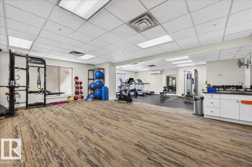 Fitness facility featuring mixed flooring surfaces, recessed lighting, and integrated cabinetry - #1102 10909 103 Av Nw, Edmonton, AB - Indoor