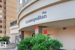 Curved building facade with "The Cosmopolitan" signage, ground-floor entry, exterior light fixtures, and low-maintenance landscaping - 