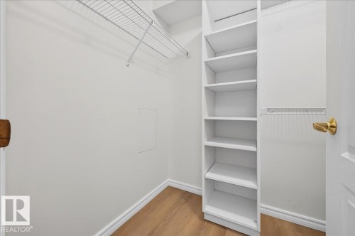 Custom closet system featuring shelving units, wire racks, and wood-finish flooring - #1102 10909 103 Av Nw, Edmonton, AB - Indoor With Storage