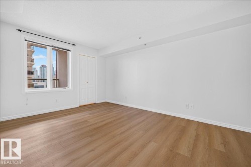 Recessed lighting, wood-finish flooring, white walls, and a double-pane window - #1102 10909 103 Av Nw, Edmonton, AB - Indoor Photo Showing Other Room