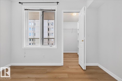 Light wood-finish flooring, white walls, and a window with blinds - #1102 10909 103 Av Nw, Edmonton, AB - Indoor Photo Showing Other Room