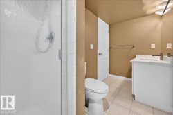Bathroom featuring a single vanity with an integrated sink, polished chrome faucet, and white cabinetry - 