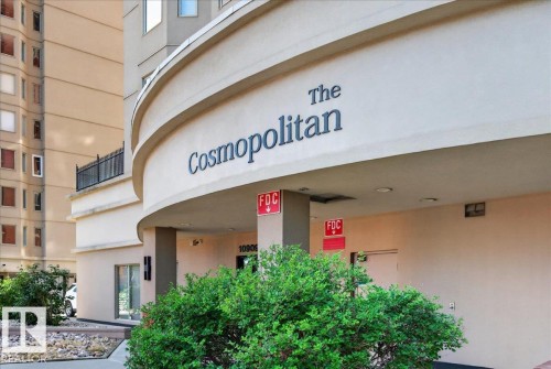 Curved building facade with "The Cosmopolitan" signage, ground-floor entry, exterior light fixtures, and low-maintenance landscaping - #1102 10909 103 Av Nw, Edmonton, AB - Outdoor