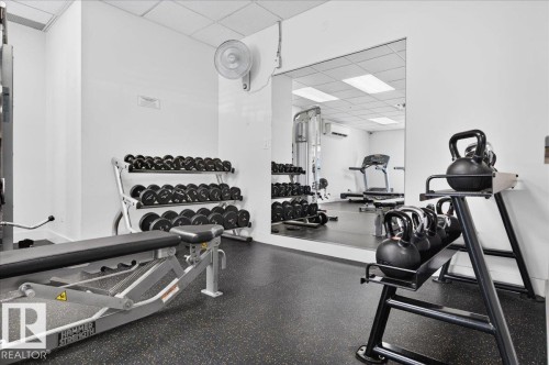 Fitness area with rubberized flooring, mirrored wall, and recessed lighting - #1102 10909 103 Av Nw, Edmonton, AB - Indoor Photo Showing Gym Room