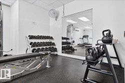 Fitness area with rubberized flooring, mirrored wall, and recessed lighting - 