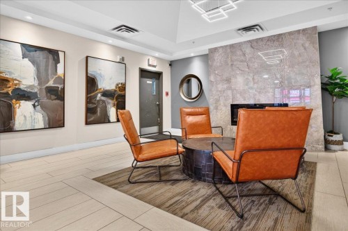 Recessed lighting, wood-finish flooring, and a stone-clad fireplace - #1102 10909 103 Av Nw, Edmonton, AB - Indoor Photo Showing Other Room