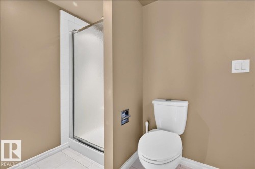 Shower enclosure with frosted glass door, white toilet, and light neutral wall finishes - #1102 10909 103 Av Nw, Edmonton, AB - Indoor Photo Showing Bathroom