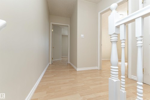 Hardwood-finish flooring, white wall paint, classic white trim, and a white balustrade - 12241 93 Street Nw, Edmonton, AB - Indoor Photo Showing Other Room