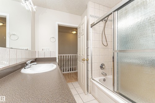 Bathroom featuring a single vanity with an integrated sink, chrome faucet, and a large mirror - 12241 93 Street Nw, Edmonton, AB - Indoor Photo Showing Bathroom