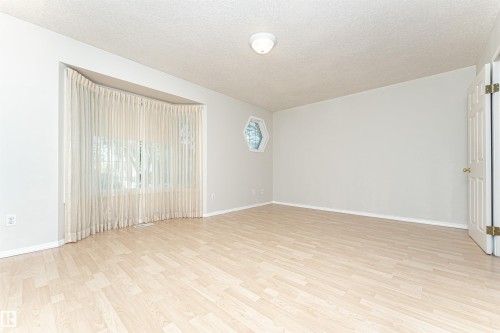 Light wood-finish flooring, hexagon window, and a curved window wall - 12241 93 Street Nw, Edmonton, AB - Indoor Photo Showing Other Room